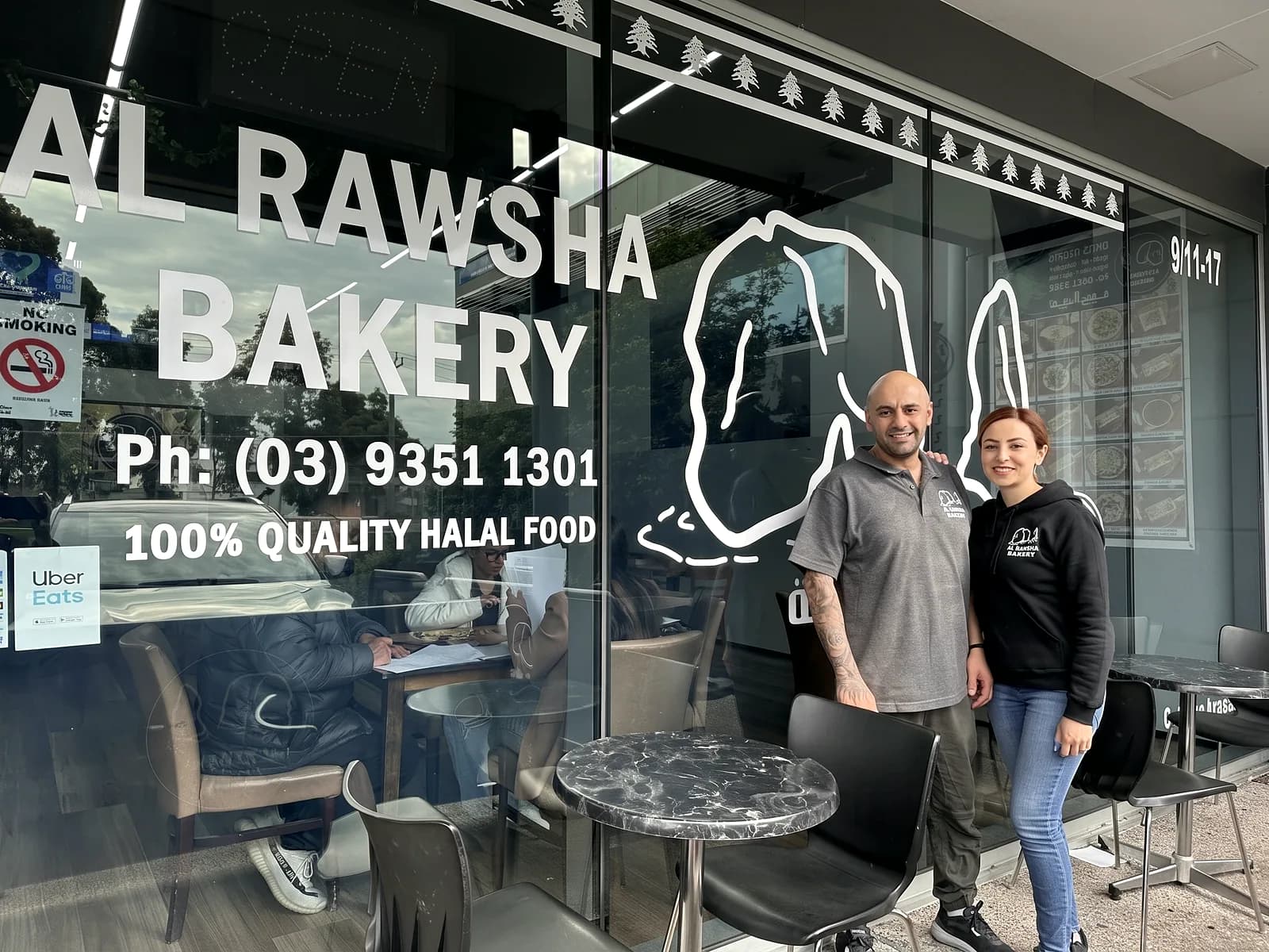 Rima and George outside the shop